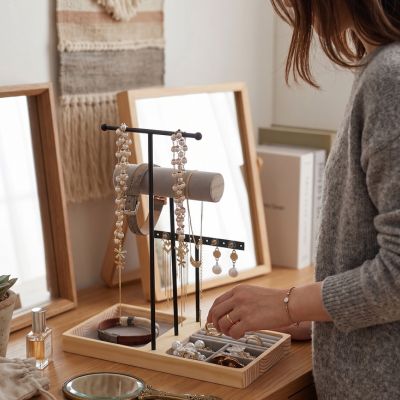 Porte bijoux sur coiffeuse avec femme qui range ses bijoux