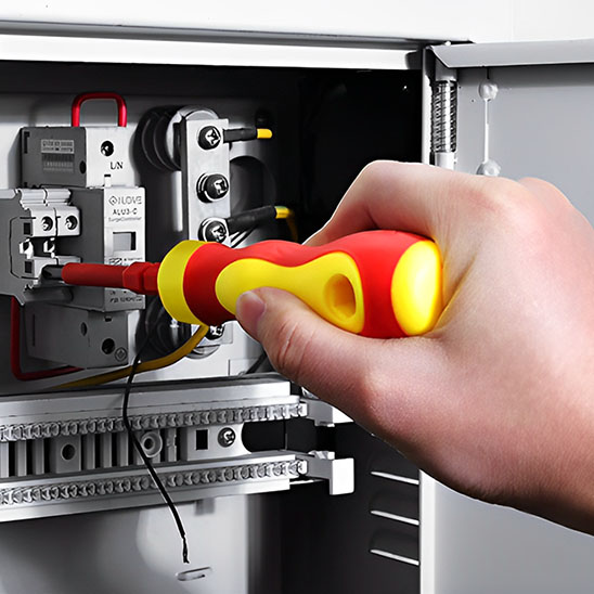Tournevis rouge jaune effectuant travaux électrique