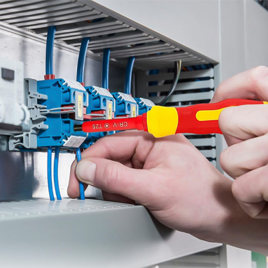 Tournevis jaune rouge fixant des composants électrique