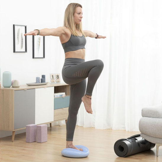 Une Femme en équilibre sur Tapis Pilates dans salon lumineux