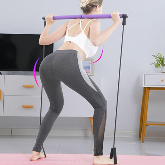 Femme de dos faisant squat avec élastique musculation a domicile.
