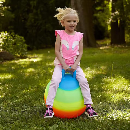 fillette de 6ans sur son Ballon sauteur multi colore  avec poignée d'équilibre