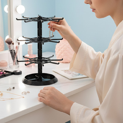 Porte bijoux noir posé sur la coiffeuse devant le miroir devant une jeune femme