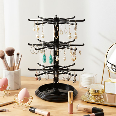 Porte bijoux noir rempli de bijoux posé sur la coiffeuse devant le miroir