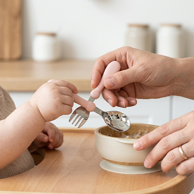 la cuillère et la fourchette du Couvert pour bebe se croisent autour du bol de puree